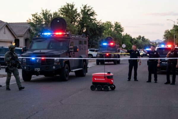 Image for: An Autonomous Food Delivery Robot Operated By DoorDash Rolled Through The Middle Of An Active SWAT Standoff In Chandler, Arizona, Disregarded Police Commands To Vacate The Area, And Reportedly Refused To Leave; The Robot Is Named Dot; It Is Red; It Is About Five Feet Long; It Is Built On Six Wheels; It Was Trying To Deliver Food; Brent Has Driven Through Arizona Twice; Brent Has Driven Past A Chandler Exit Once; Brent Is Going To Cover This Story Anyway